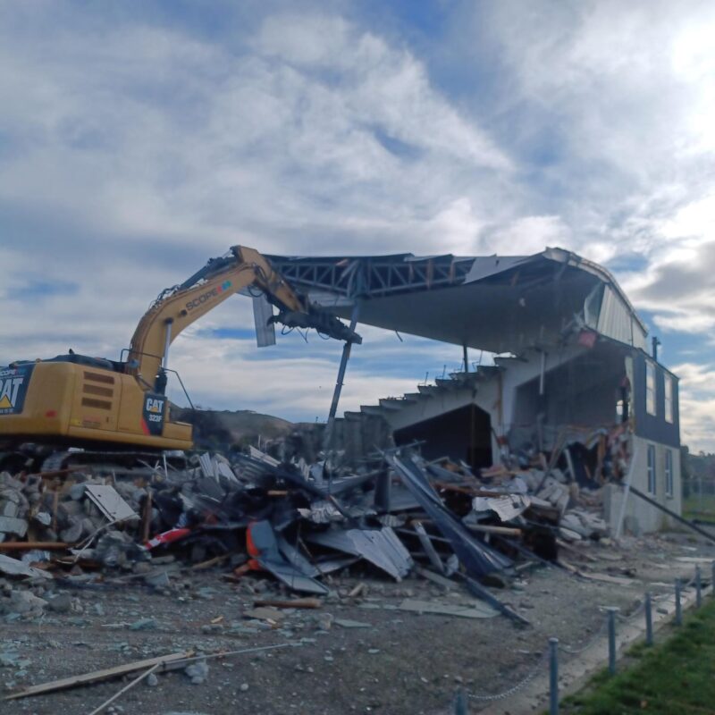 image of Scope Group excavator demolishing rugby grandstand in North Otago, New Zealand