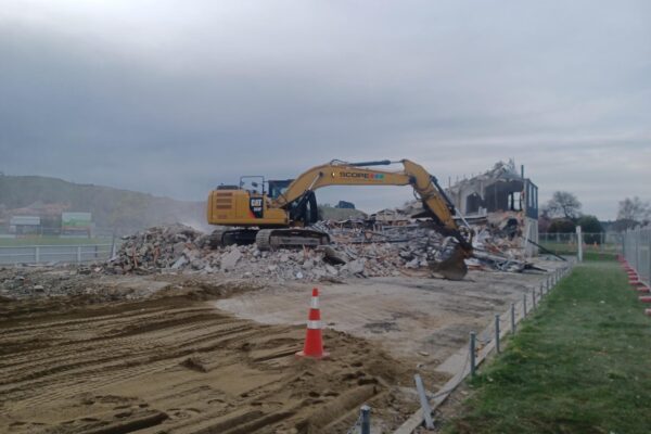 image of Scope Group excavator demolishing rugby grandstand in North Otago, New Zealand
